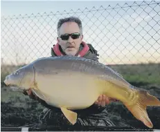  ??  ?? Big fish angler Andy Mason is pictured with a huge carp taken from the Lapwing Pool at Float Fish Farm recently.