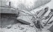  ?? JASON CATO Pittsburgh Tribune-Review ?? The collapse of the bridge spanning a ravine required rescuers to rappel nearly 150 feet while others formed a human chain to help rescue multiple people from a dangling bus Friday.