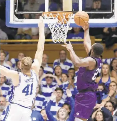  ?? AP ?? Stephen F. Austin forward Nathan Bain drives for the game-winning basket over Duke forward Jack White during overtime on Tuesday night in Durham, N.C. Stephen F. Austin won 85-83.