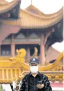  ?? AP ?? A resident looks out near the Yellow Crane Tower in central China’s Wuhan province on Wednesday, April 1, 2020.