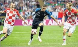  ?? FRANCK FIFE/AFP/GETTY IMAGES ?? France forward Kylian Mbappe, center, vies with Croatia’s defender Ivan Strinic, right, and forward Ivan Perisic during Sunday’s final. Mbappe, 19, became only the second teenager to score a goal in a final, joining Pele.