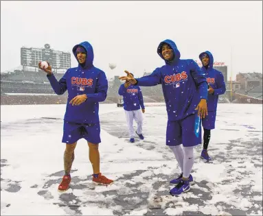  ?? Brian Cassella / Associated Press ?? Chicago Cubs players throw snowballs at Wrigley Field in Chicago earlier this month. The Register’s Joe Morelli says it’s time to at least look at a 150-game MLB slate and start the season in mid-April.