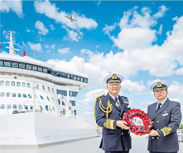  ?? ?? Admiral Sir Jonathon Band (left), the former First Sea Lord and Chief of Naval Staff hand-delivers the last of almost 100 poppy wreaths to Captain Andrew Hall, Master of Queen Mary 2, before they set sail for New York