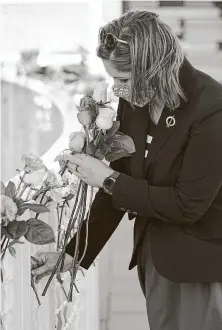  ?? John Raoux / Associated Press ?? Crissy Sokol places a flower at the Space Mirror Memorial during Thursday’s ceremony at the Kennedy Space Center.