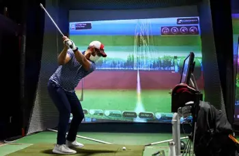  ?? Hyoung Chang, The Denver Post ?? Rouhin Sen of Denver uses a simulator during practice at Optimum Golf in Denver on Wednesday.