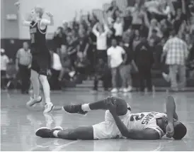  ?? STAFF PHOTO BY ERIN O. SMITH ?? Tyner’s Javon Craddock falls on the floor injured as Signal Mountain celebrates scoring in the background during the District 6-AA boys’ basketball championsh­ip game between Tyner and Signal Mountain Tuesday at Howard.