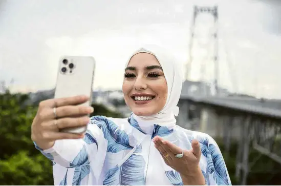  ?? Anderson Coelho/Folhapress ?? A brasileira Mariam Chami faz selfie na Ponte Hercílio Luz, em Florianópo­lis, onde mora; filha de libanês, fala com bom humor sobre o islã