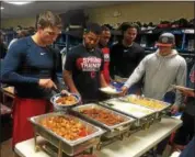  ?? DAVID S. GLASIER — THE NEWS-HERALD ?? Captains players dig into a postgame spread prepared by teammates Domingo Jimenez and Gregori Vasquez.