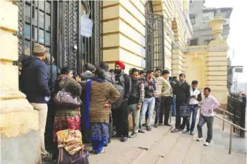  ?? — AP photos ?? NEW DELHI: Indians stand in a queue outside a bank.