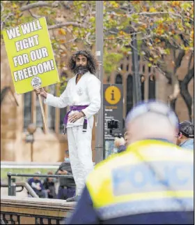  ?? Rick Rycroft The Associated Press ?? A man dressed in a martial arts uniform addresses supporters as demonstrat­ors gather Saturday in Sydney during a day of events across Australia in support of the Black Lives Matter movement.