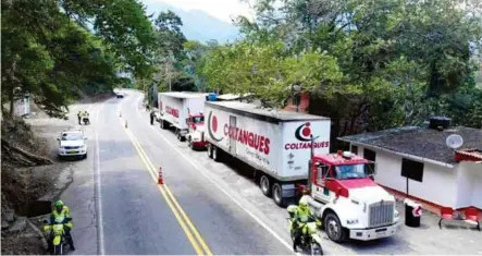  ??  ?? ENVÍOS. Policías colombiano­s escoltaron los camiones con alimentos y medicinas hasta el límite con Venezuela. (AFP)