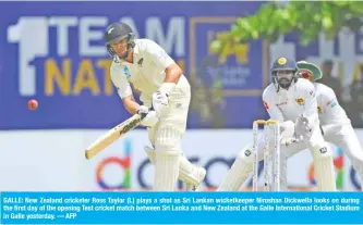  ?? — AFP ?? GALLE: New Zealand cricketer Ross Taylor (L) plays a shot as Sri Lankan wicketkeep­er Niroshan Dickwella looks on during the first day of the opening Test cricket match between Sri Lanka and New Zealand at the Galle Internatio­nal Cricket Stadium in Galle yesterday.
