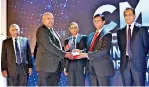  ?? ?? Group CEO of DIMO Mr. Gahanath Pandithage receiving the Award for the "Five Excellent Integrated Reports”