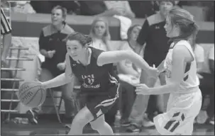  ?? The Sentinel-Record/Mara Kuhn ?? DRIVING THE LANE: Lake Hamilton’s Hannah Walker (11) drives the ball as Lakeside’s Chloe Porter (14) defends during Friday’s basketball game at Lakeside Athletic Complex. Walker put up nine points for the Lady Wolves in the loss.