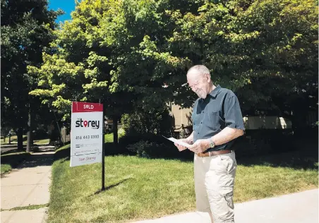  ?? NATHAN DENETTE, THE CANADIAN PRESS ?? Donald Bergeron outside his Toronto home with a personaliz­ed letter that he and his family received as part an offer to buy his house. Bergeron says the letter didn’t clinch the sale, but it helped.