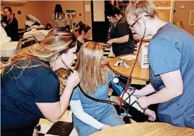  ?? [PHOTO PROVIDED] ?? Badillo supervises students as they learn how to take a patient’s vital signs.