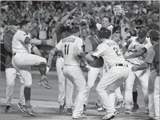  ?? JULIE JACOBSON/AP PHOTO ?? Jose Bautista of the Mets (11) is mobbed at the plate by teammates after hitting a walkoff grand slam in the ninth inning of Friday’s game against the Rays at New York. The Mets won 5-1.