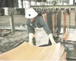  ??  ?? FILE PHOTO: A worker stacking copper plates at a plant in Zambia’s copper-mining region