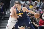  ?? DAVID ZALUBOWSKI — THE ASSOCIATED PRESS ?? Denver Nuggets center Nikola Jokic, front, drives past Portland Trail Blazers center Cody Zeller in the first half Sunday in Denver.