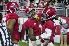  ?? VASHA HUNT — THE ASSOCIATED PRESS ?? Alabama wide receiver Jameson Williams (1) celebrates a touchdown pass reception by wide receiver John Metchie III (8) during the first half of an NCAA college football game against LSU, Saturday, Nov. 6, 2021, in Tuscaloosa, Ala. Alabama offensive lineman Chris Owens (79) looks on.