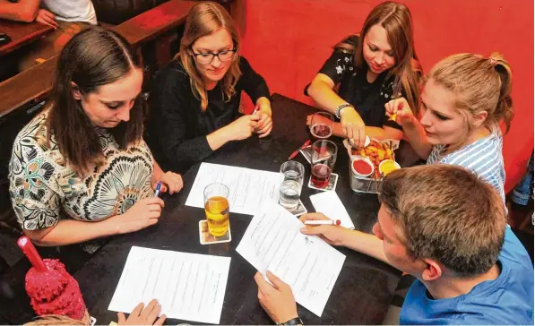  ?? Fotos: Bernd Hohlen ?? Pub Quiz im Murphy’ s Law. Dieses Team versucht, die Quizfragen zu lösen. Insgesamt werden vier Runden gespielt. Die Siegerteam­s bekommen als Gewinn Getränke.