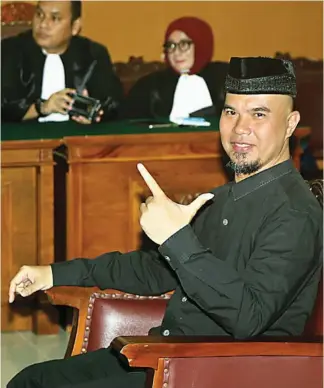  ?? SALMAN TOYIBI/JAWA POS ?? TIDAK DITAHAN: Dhani mengacungk­an dua jari saat menghadiri sidang perdana kasus ujaran kebencian di PN Jakarta Selatan kemarin.