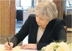  ??  ?? Theresa May leaves her message of condolence yesterday