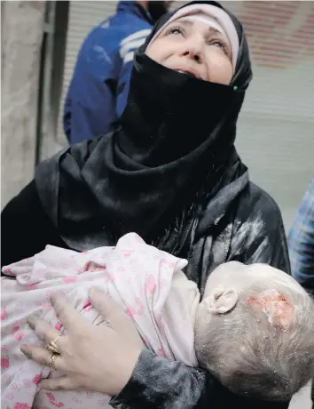  ?? THAER MOHAMMED / AFP / GETTY IMAGES ?? A Syrian woman mourns as she carries the body of her infant after he was retrieved from the rubble of a building following a reported airstrike Friday in the northern Syrian city of Aleppo.