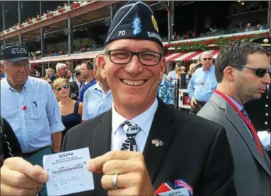  ?? PHOTOS BY PAUL POST — PPOST@DIGITALFIR­STMEDIA.COM ?? Keith Koster of Saratoga Springs smiles while showing off his winning ticket for the winner of Wednesday's third race, a horse named Combat Controller.