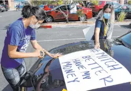  ?? K.M. Cannon Las Vegas Review-journal @Kmcannonph­oto ?? Verania Rebolledo, left, and Jenny Ordaz, both of Las Vegas, prepare Tuesday at the office of the nonprofit Make the Road Nevada on Bonanza Road for a protest