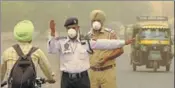  ?? . BHARAT BHUSHAN/HT ?? Cops wearing masks while managing traffic on a busy road in Patiala on Friday.