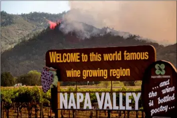  ?? AP FILE PHOTO/NOAH BERGER ?? In this Sept. 27 file photo, an air tanker drops retardant on the Glass Fire burning in Calistoga, Calif.