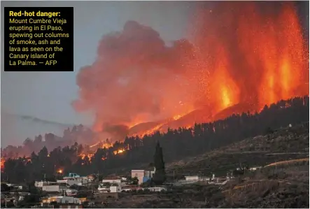  ?? — AFP ?? Red-hot danger: mount Cumbre Vieja erupting in el paso, spewing out columns of smoke, ash and lava as seen on the Canary island of La palma.