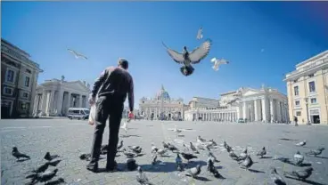  ?? AFP ?? ■
A homeless man feeds pigeons at the border between Italy and The Vatican during the lockdown.