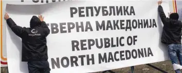  ?? — Reuters ?? Workers set up a sign with Macedonia’s new name at the border between Macedonia and Greece, near Gevgelija, Macedonia, on Wednesday.