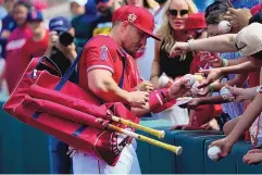  ?? MATT YORK/ASSOCIATED PRESS ?? Los Angeles Angels star Mike Trout signs autographs prior to his team’s spring training game against Cleveland on Monday in Tempe, Ariz. Trout joins the United States team for the World Baseball Classic.