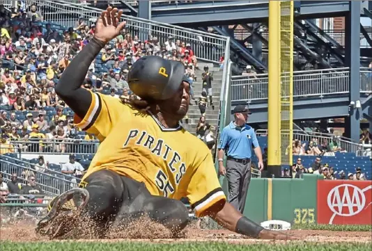  ?? Matt Freed/Post-Gazette photos ?? Josh Bell slides safely into home on a Jose Osuna single to tie the score, 3-3, in the fourth inning Sunday at PNC Park.