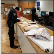  ?? NWA Democrat-Gazette/ASHTON ELY ?? Cpl. Marcus Peace and Officer Seay Floyd work to sort through some of the mail that was scattered during Tuesday night’s mail thefts across east Fayettevil­le.