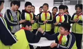  ?? ?? Students engage in arm wrestling matches between classes at a school in Shandong Province. — Photos / IC