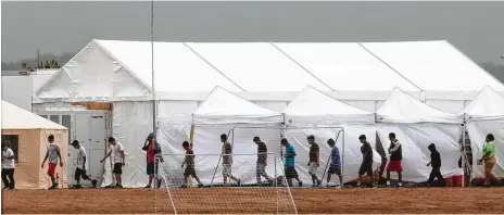  ?? Ivan Pierre Aguirre for the San Antonio Express-News ?? Children walk through the 400-bed tent facility for youth in Tornillo, which has become a focal point in the immigratio­n battle.