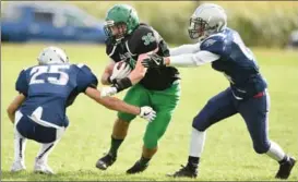  ?? PETER LEE, RECORD STAFF ?? Crusaders ballcarrie­r Evan Bender, centre, is tackled by Hawks players Owen McDonald, right, and Nick Kincaid.