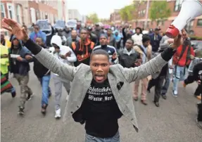  ?? CHIP SOMODEVILL­A/GETTY IMAGES ?? Hundreds of demonstrat­ors march toward the Baltimore Police Western District station after the death of Freddie Gray in the back of a police van in April 2015.