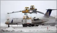  ?? DAVID ZALUBOWSKI — THE ASSOCIATED PRESS ?? A United Express airplane is sprayed with deicing fluid while waiting for take off from Denver Internatio­nal Airport as travelers deal with the spread of the coronaviru­s Friday in Denver.