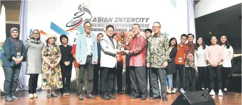  ??  ?? Padawan Municipal Council deputy chairman Dato Ahmad Ibrahim (second right) receives the overall championsh­ip trophy from AIBC deputy president Johnson Cheng while Abas president Sunny Si (right), Lu (left) and others look on.