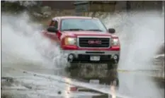  ?? CHRIS MACHIAN — OMAHA WORLD-HERALD VIA AP ?? A truck drives southbound through flood water on 60th Street Wednesday in Omaha, Neb. A vast and powerful storm is bringing blizzards, floods and a tornado to more than 25 states, stretching from the northern Rocky Mountains to Texas and beyond. Flooding forced evacuation­s in northeast Nebraska and western Iowa.