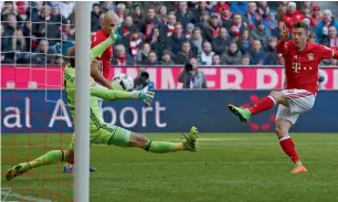  ??  ?? Robert Lewandowsk­i scores a goal against Hamburg during a Bundesliga match. — Reuters