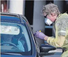  ?? CLIFFORD SKARSTEDT EXAMINER ?? A health-care worker takes a sample an employee from Fairhaven during COVID-19 testing at a drive-thru station outside the Dutton Road long-term care home on Saturday.