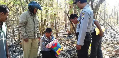  ?? POLSEK WONGSOREJO FOR JAWA POS RADAR BANYUWANGI ?? DI LOKASI: Bayi perempuan yang ditemukan di hutan Dusun Pringgonda­ni, Desa Watukebo, diamankan petugas Puskesmas Bajulmati dan Polsek Wongsorejo kemarin (16/7).