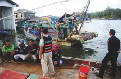  ??  ?? NARATHIWAT: Vietnamese fishermen are seen in a boat after being detained by the Royal Marine Police in Thailand’s southern province of Narathiwat. Police arrested the nine Vietnamese men for illegal fishing in Thai waters. — AFP