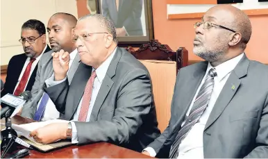  ?? NORMAN GRINDLEY/CHIEF PHOTO EDITOR ?? PNP President Peter Phillips (second right) speaks to journalist­s at a press conference organised to name his shadow Cabinet. With him are Dr Wykeham McNeill (left), Julian Robinson (second left), and Fitz Jackson.